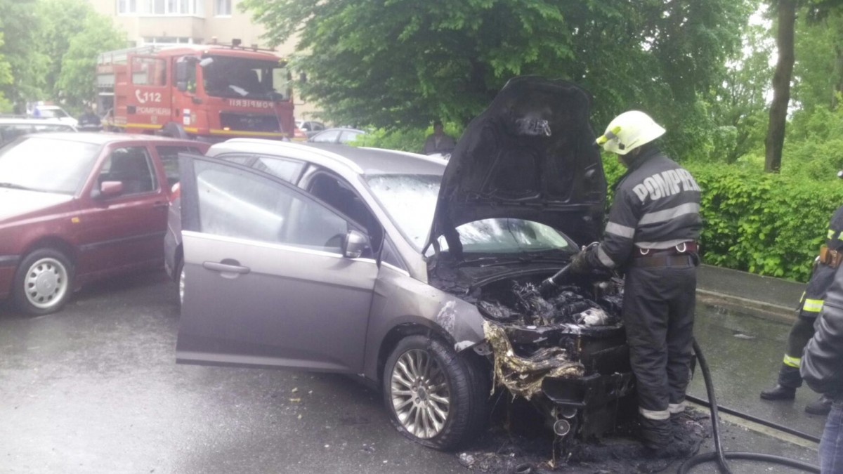 FOTO O mașină a luat foc în fața blocului