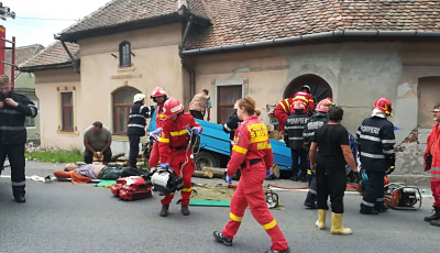 FOTO/VIDEO O mașină cu lemne a intrat într-o casă, pe DN1. Trei victime încarcerate