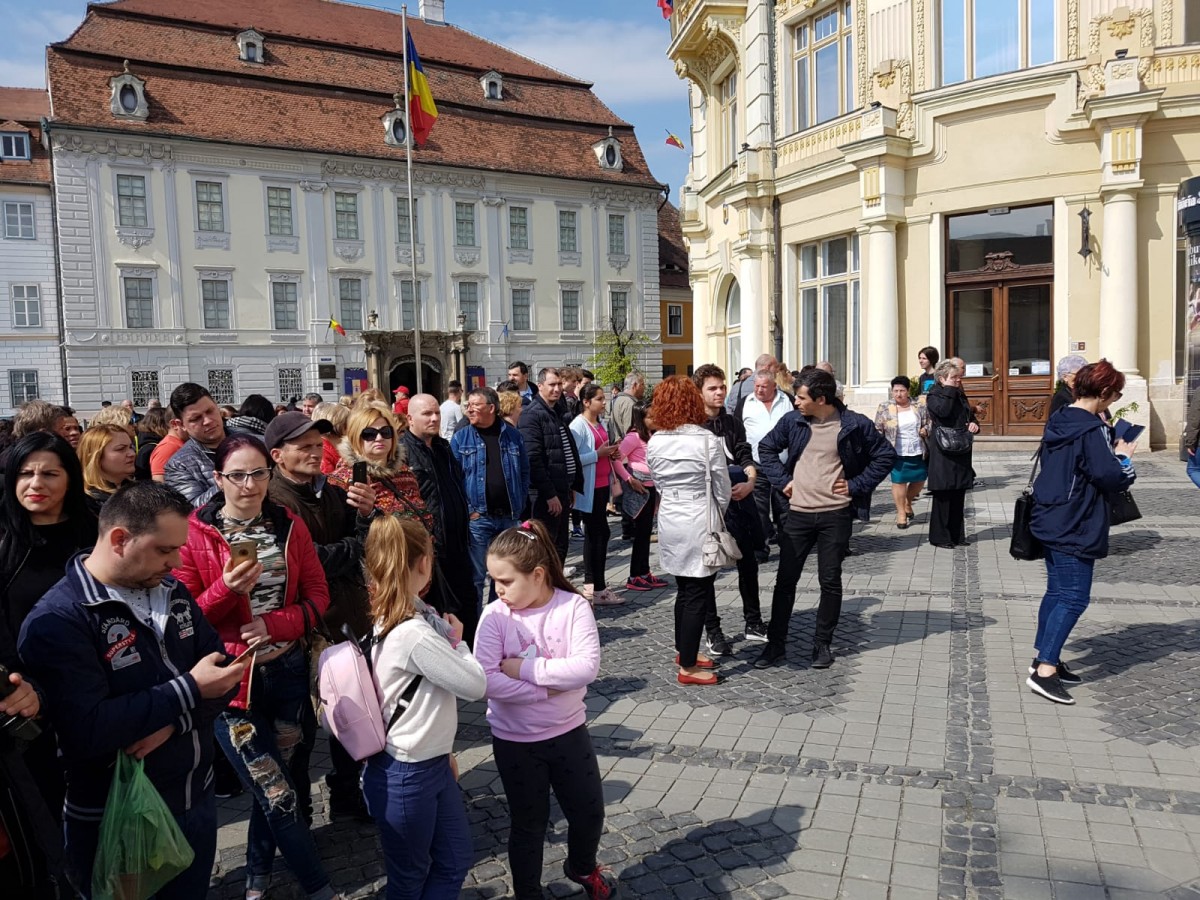 FOTO-VIDEO Președintele Iohannis și soția, așteptați de zeci de oameni și aplaudați în Piața Mare