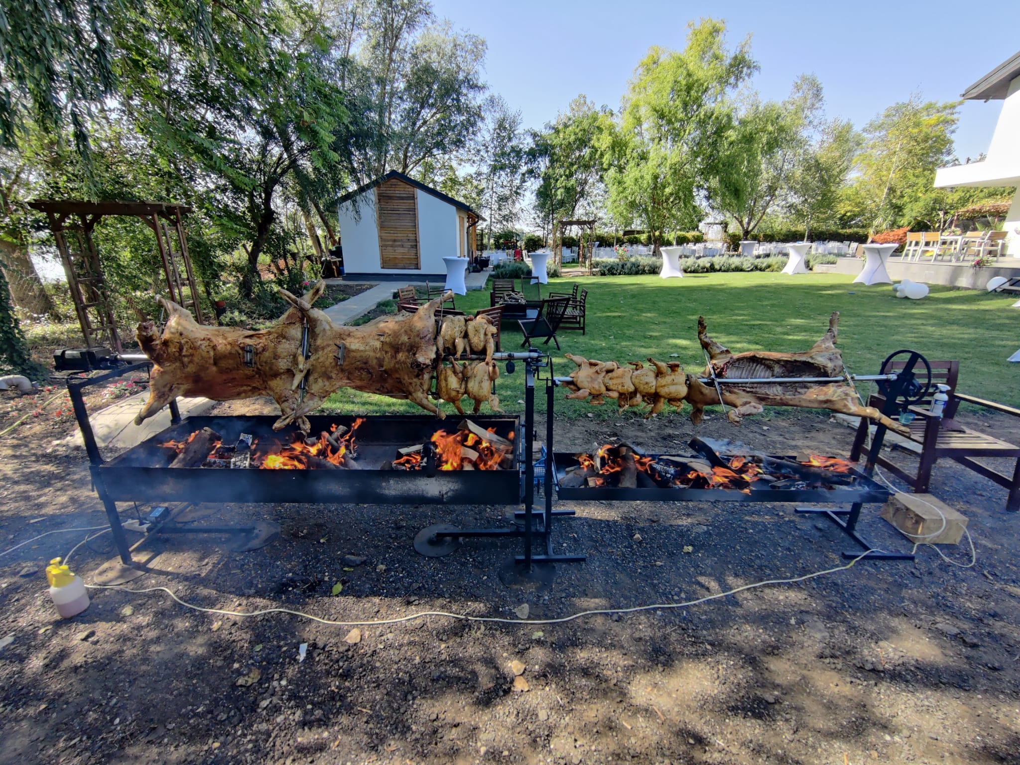 Doi tineri pregătesc carne la proțap și ceaune pentru evenimentele sibiene