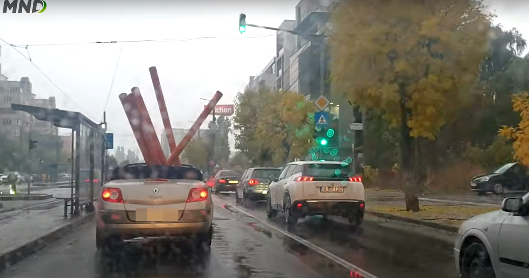 Imagini virale. Craiovean, filmat în timp ce transporta cu un Renault Megane decapotabil mai multe țevi, pe ploaie