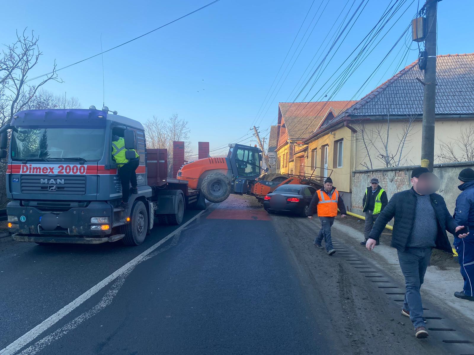 Mașină, stâlp și conductă de gaz avariate în Slimnic, după ce un compactor a căzut de pe o platformă