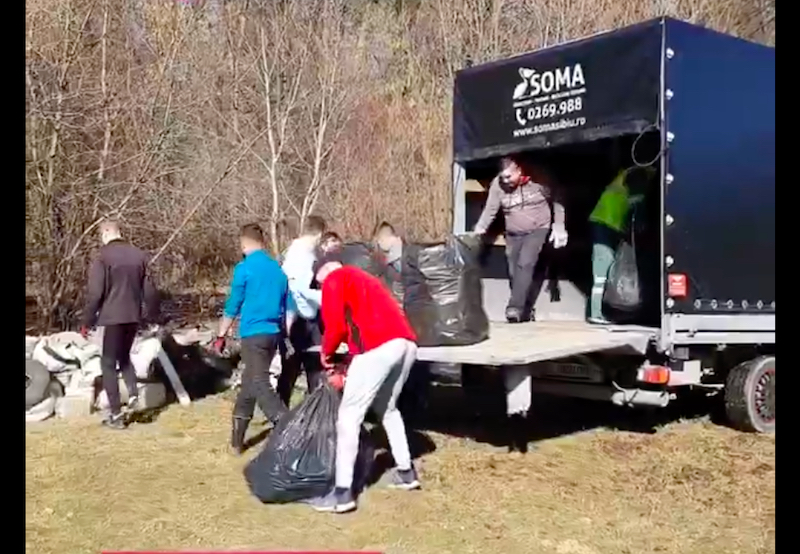 VIDEO-Câțiva voluntari, unii sosiți din SUA, au strâns două tone de gunoaie de pe marginea drumului, în Pădurea Cisnădioara