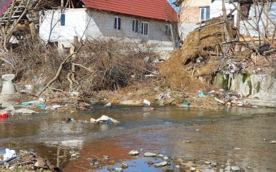 FOTO-Amenzi fără precedent în județ. Zeci de oameni scot gunoiul din curte și-l aruncă direct în râu