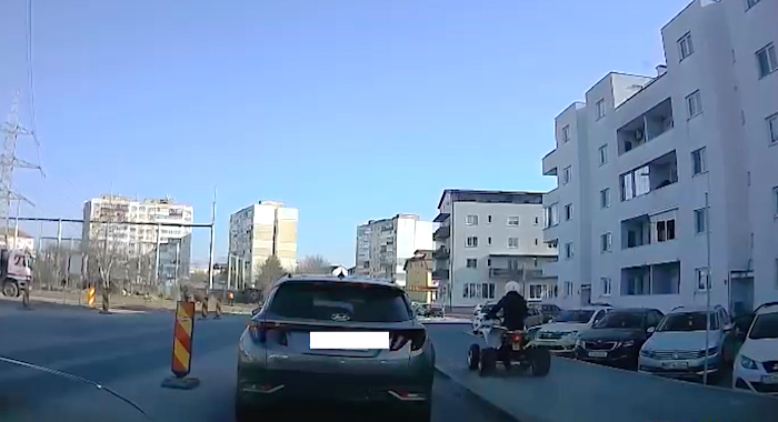 VIDEO-Karma în traficul sibian: Șoferul unui ATV depășește pe trotuar, apoi se răstoarnă în giratoriu