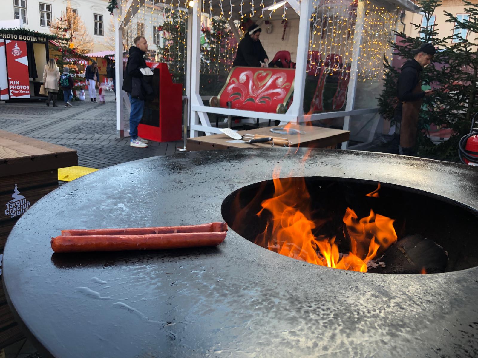 Iese fum de grătar, la Târgul de Crăciun din Sibiu. Am prăjit cârnați în Piața Mare 