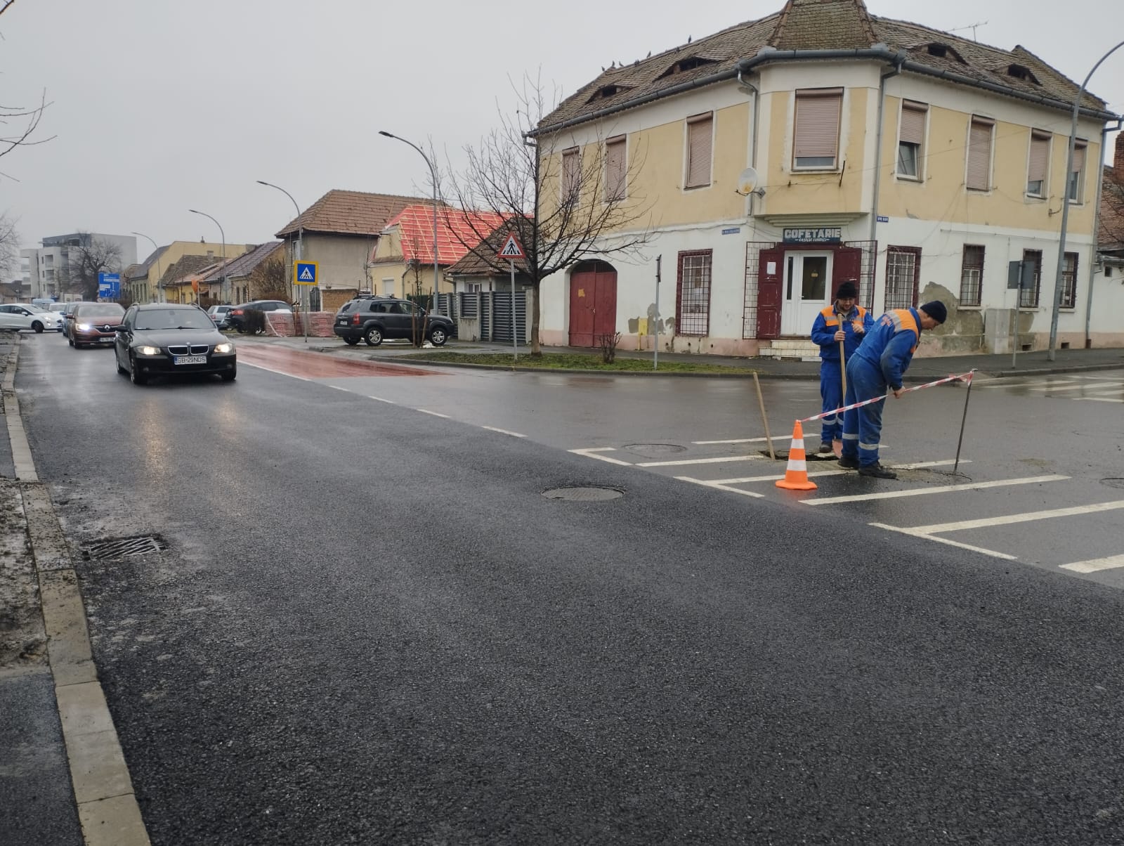 Gaură în asfalt pe strada M. Kogălniceanu. Trei angajați de la Apă Canal dirijează mașinile