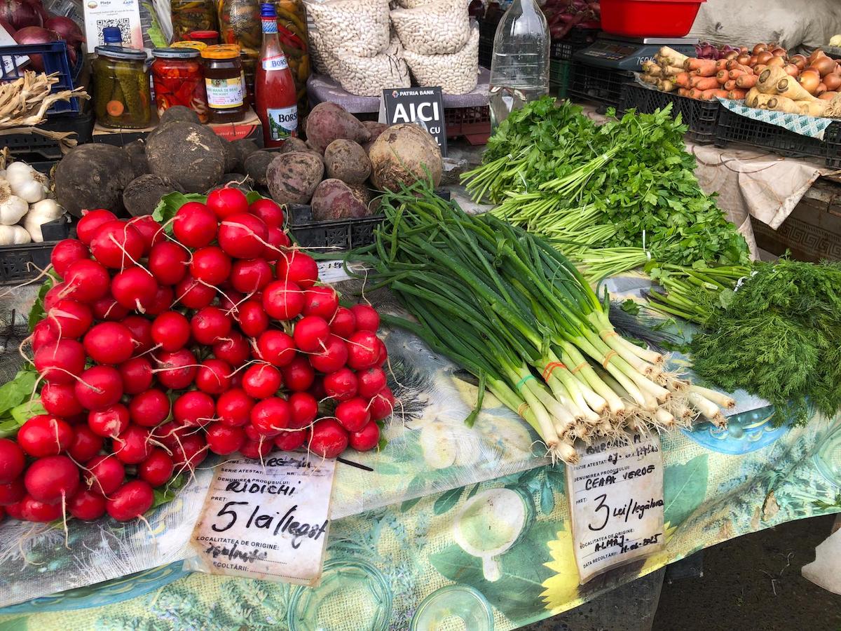 „Mesele s-au scumpit, dar noi nu scumpim”. Comercianții din Oltenia au adus verdețurile de primăvară în Piața Cibin