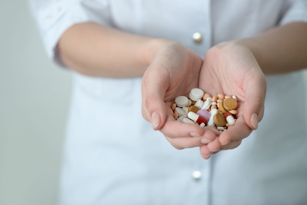 Female hands of doctor or nurse with collection of pills and dra