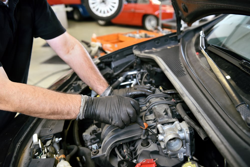 Gloved hands of a mechanic working on an engine