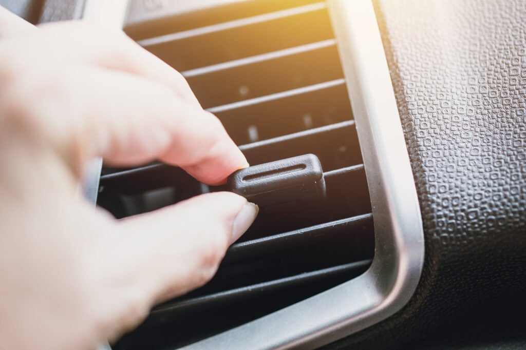 Hand adjust way air vent cooling air flow in car dashboard