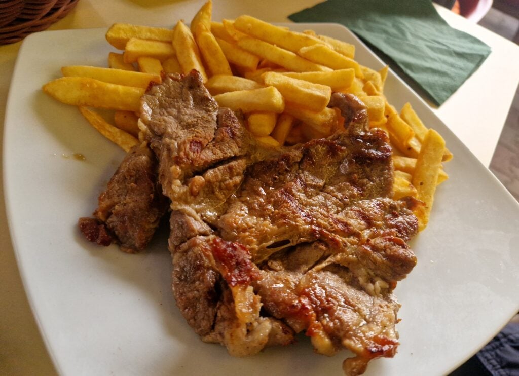 Ceafă de porc cu cartofi pai, la Taverna Amicii. Foto: turnulsfatului.ro