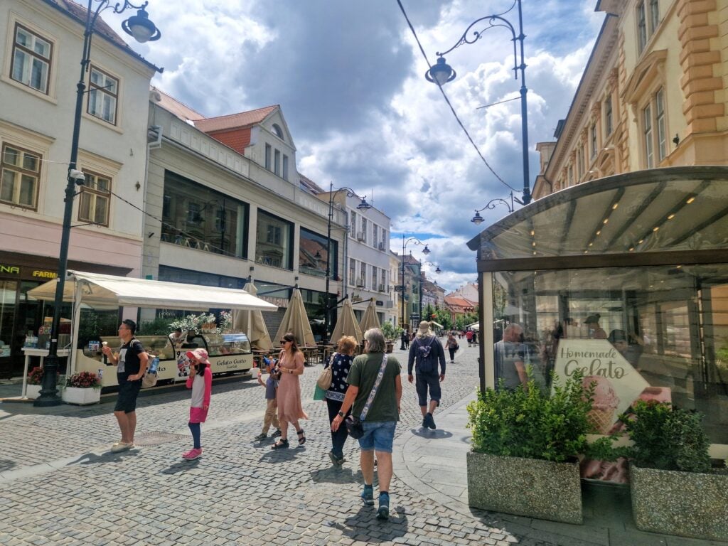 Vitrina din dreapta trebuie ridicată, fiind amenajată în cadrul unei terase sezoniere. Cea din stânga imaginii nu, fiindcă a fost amplasată conform regulamentului din 2023. Foto: turnulsfatului.ro