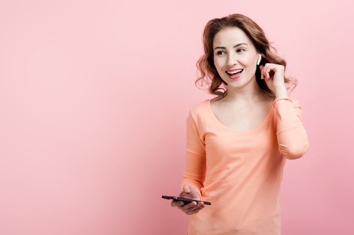 Cheerful,Girl,In,Airpods,With,Phone,Dancing,,Pink,Background.