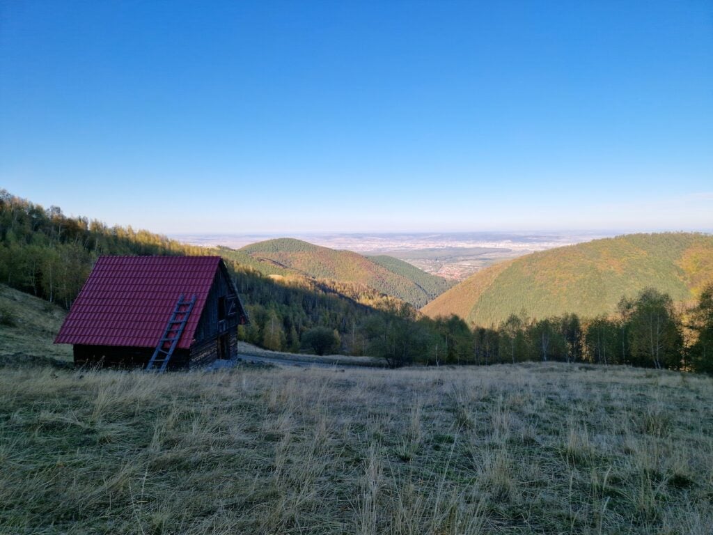 Pe locul pe care se află coliba cu acoperiș roșu ar urma săpată cariera de magneziu, îți indică ciobanii din zonă. Foto: turnulsfatului.ro