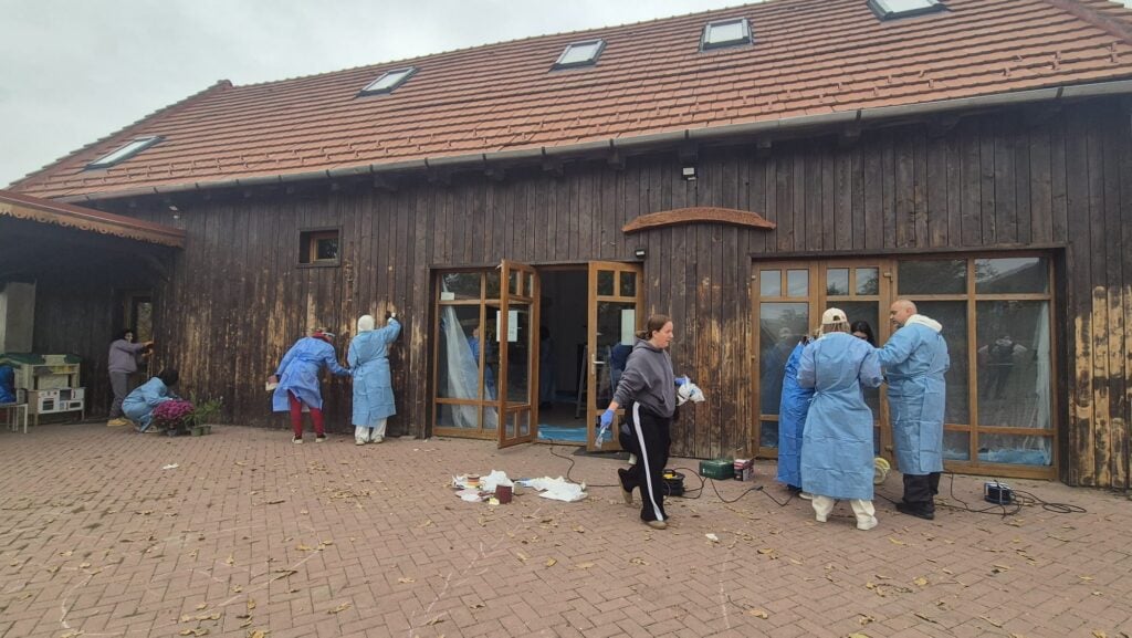 Voluntarii șlefuiesc fațada Șurii Culturale. Foto: turnulsfatului.ro